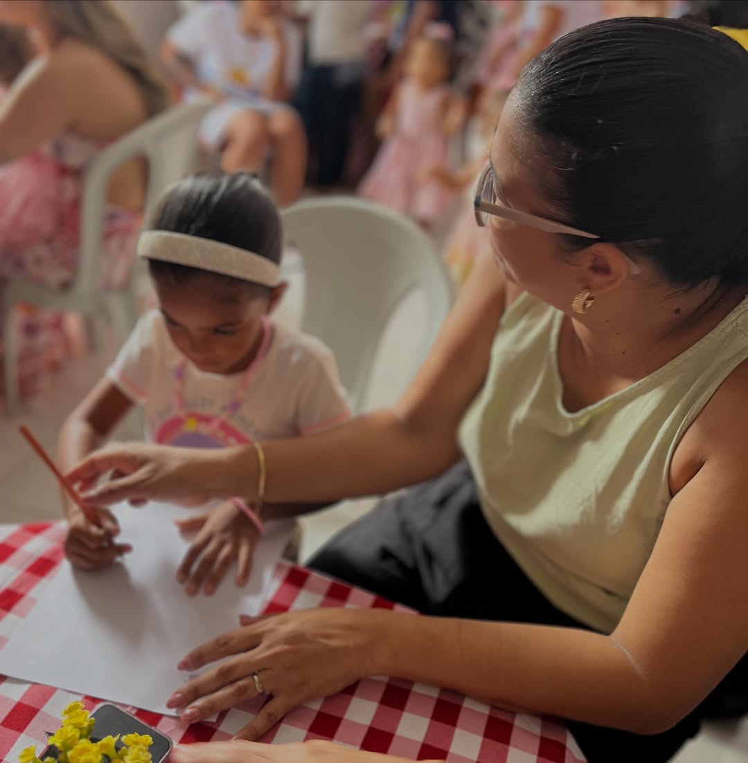 Educadora acompanhando uma criança em atividade